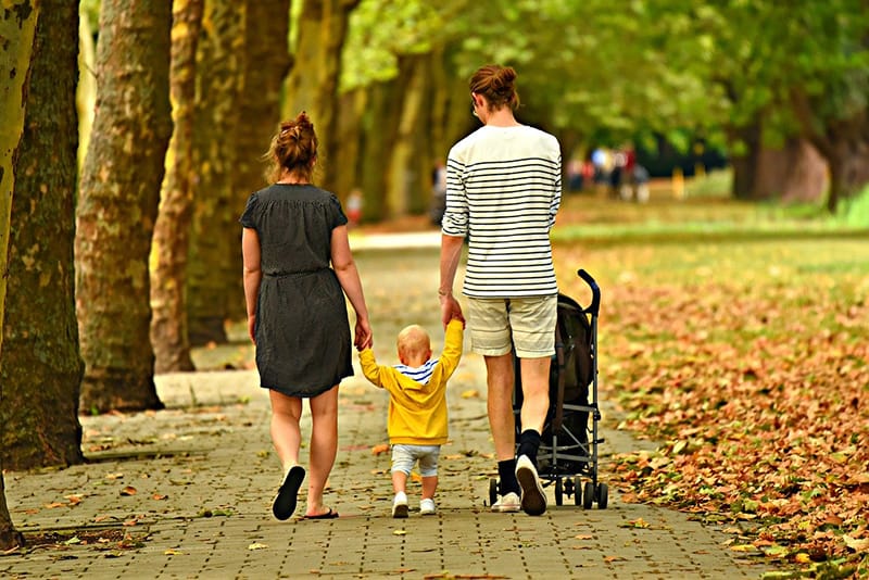 genitori che camminano con un bambino per mano
